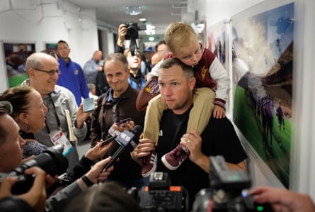 Winning ASU head coach Kenny Dillingham talks to the media in a corridor outside the changing rooms with his 3-year-old son Kent on his shoulders