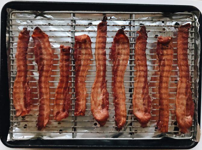 9 strips of bacon on a cooking tray.