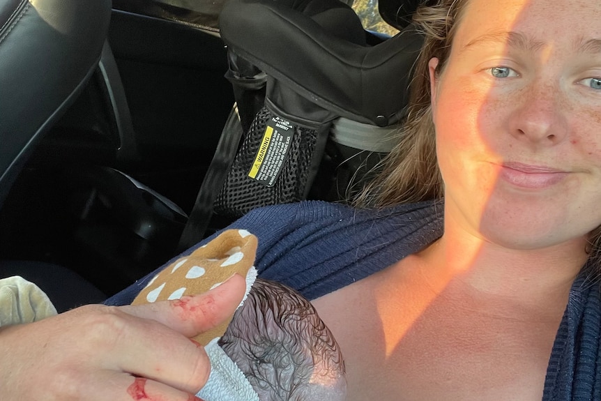 Shara Kimpton sitting in a car holding a brand new baby.