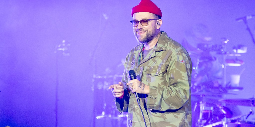 O vocalista da banda Gorillaz, Damon Albarn, segura uma bandeira palestina durante um show após a remoção de Macklemore do tour.