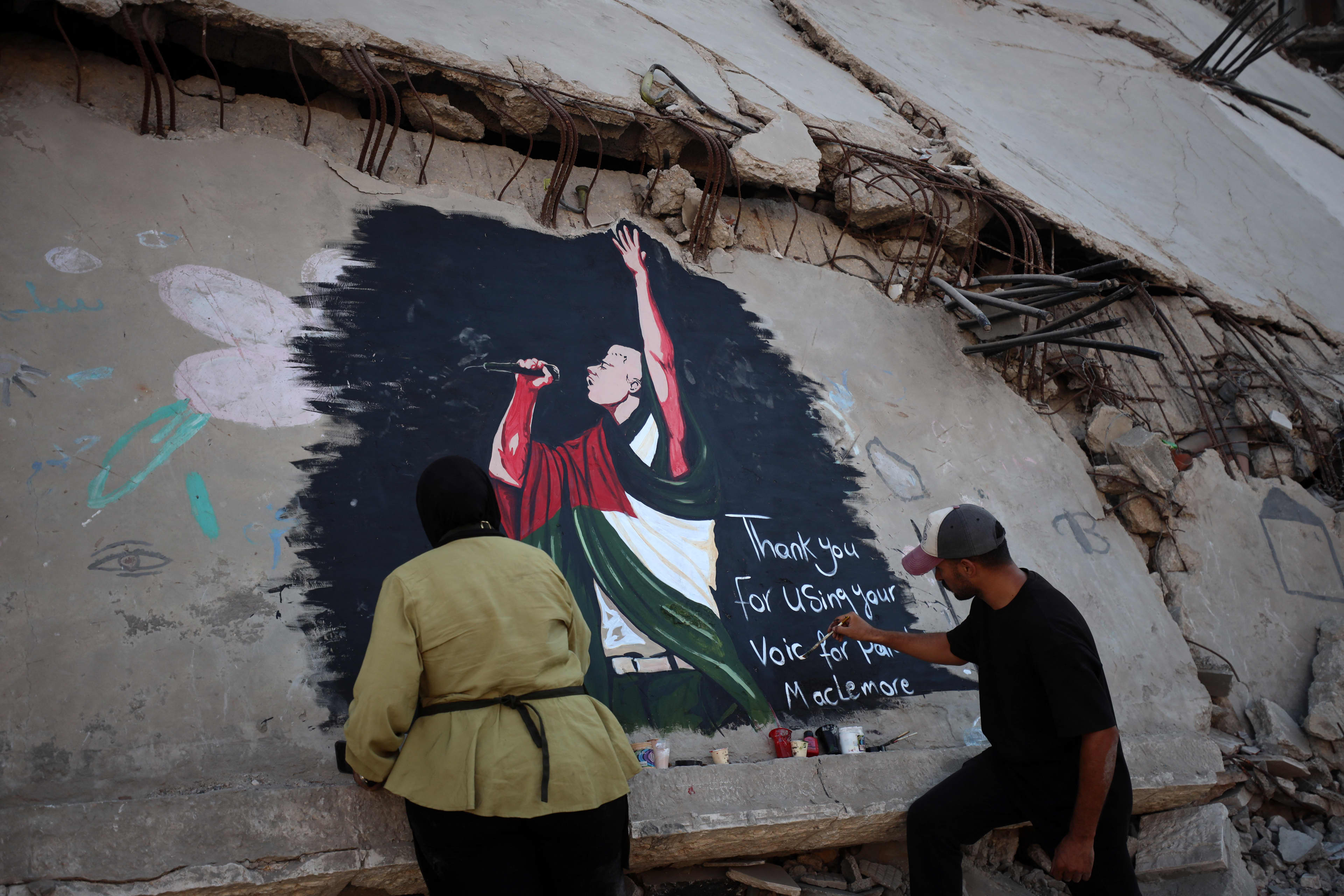 Palestinian artists put the finishing touches on a mural depicting American rapper Macklemore on the ruins of homes destroyed by the Israeli army in Gaza City, on September 17, 2026. Macklemore has become one of the American artists known for his public support for Palestinians. In September 2026, he was removed from Ed Sheeran's tour following pro-Palestinian statements made during one of his concerts. He also announced that he would donate $1 million from the proceeds of his tour to Pales