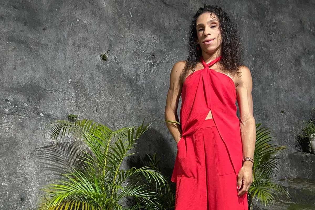 Imagem colorida de mulher branca com roupas vermelhas - Metrópoles
