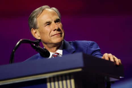 Texas Gov. Greg Abbott smiles while resting his hand on a podium