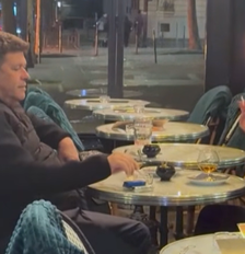Casal toma drink perto de lixeira em chamas durante protestos em Paris Foto: Reprodução